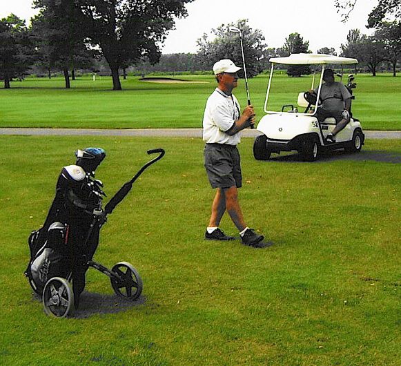 Dick Linton stares down his approach on #12, while John O'Polka looks on